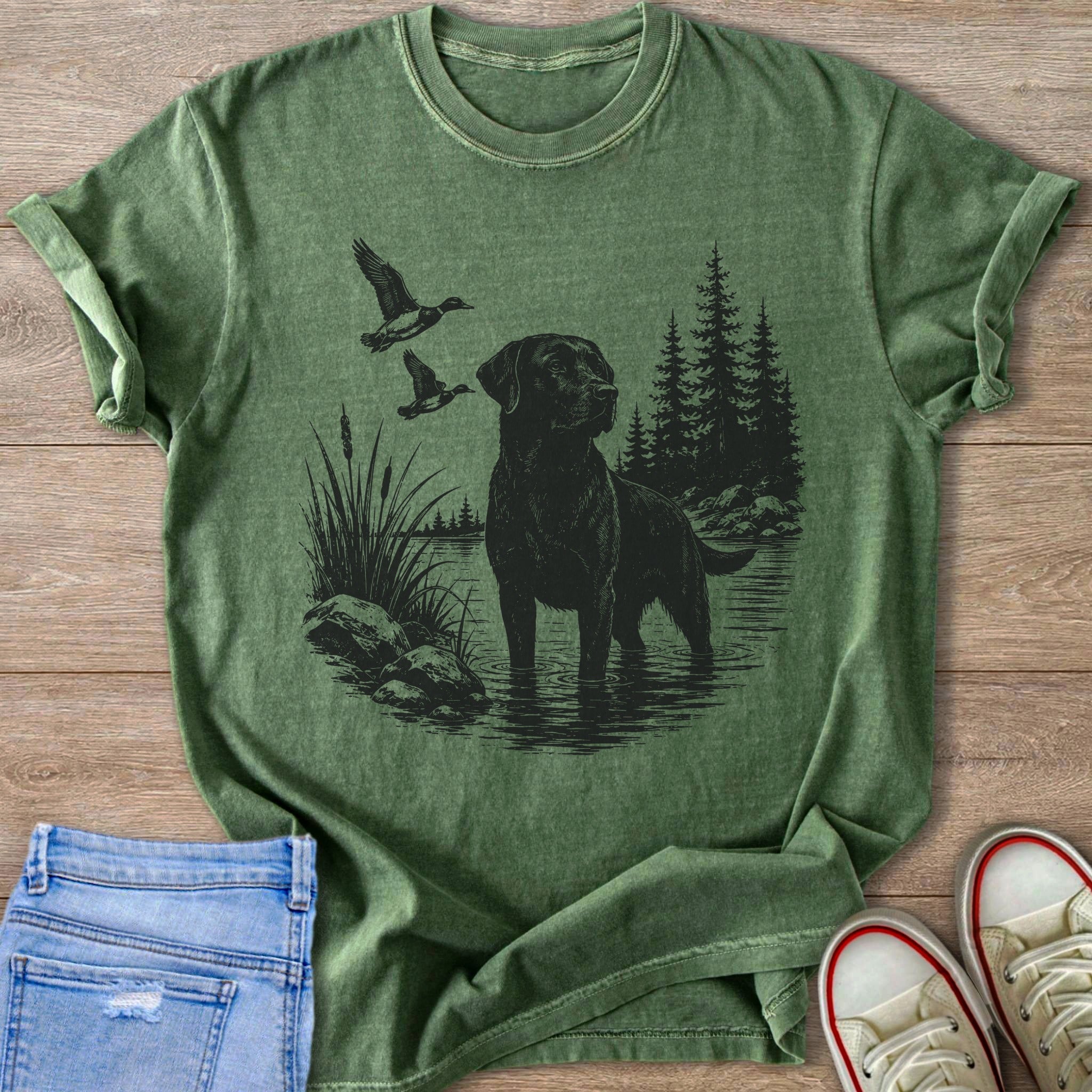 Black Labrador in water with ducks flying past pine trees.