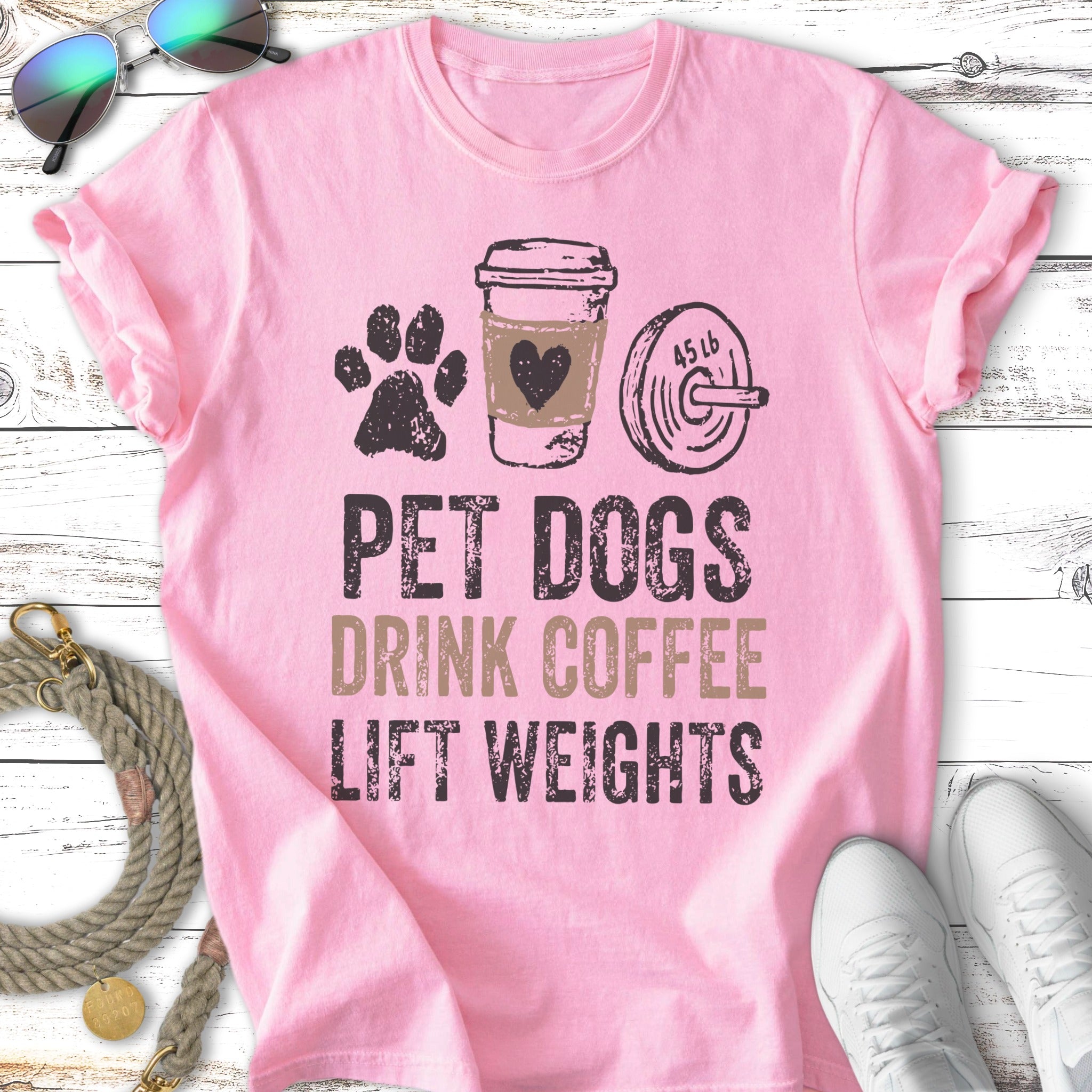 Pink t-shirt with "PET DOGS DRINK COFFEE LIFT WEIGHTS" text and graphics.