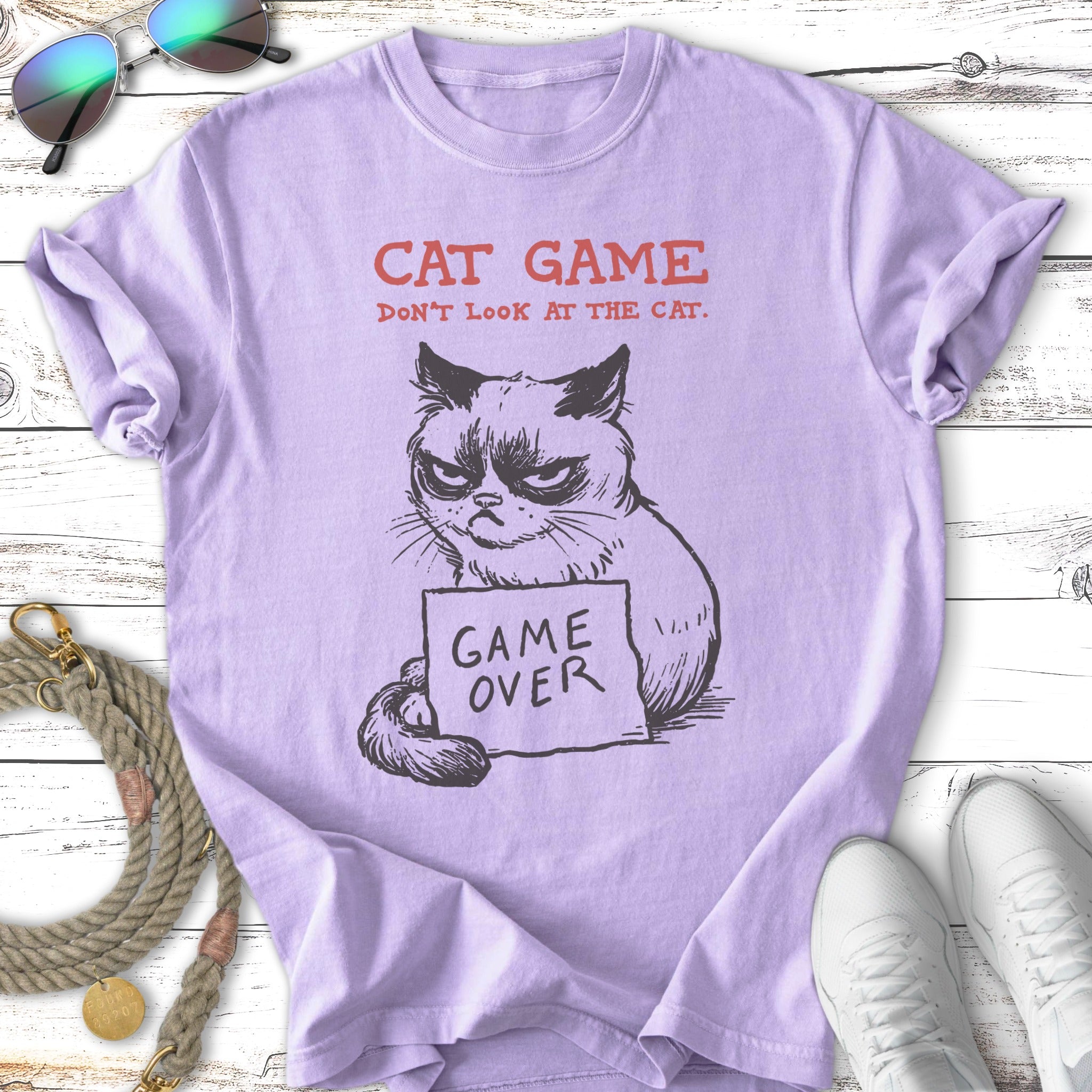 Purple t-shirt with grumpy cat illustration and text "CAT GAME" and "DON'T LOOK AT THE CAT."