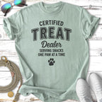 Light green t-shirt reading "Certified Treat Dealer Serving Snacks One Paw at a Time".