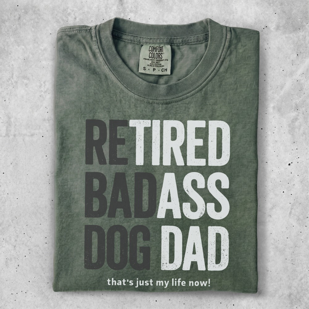 Green t-shirt with "RETIRED BADASS DOG DAD that's just my life now!" text.