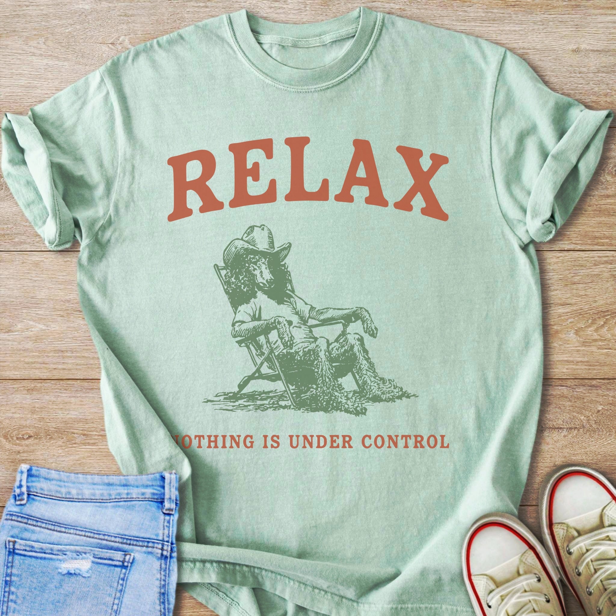 Mint t-shirt with "RELAX" and a poodle in a cowboy hat sitting in a chair.