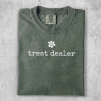 Green Comfort Colors t-shirt with "treat dealer" and a paw print.