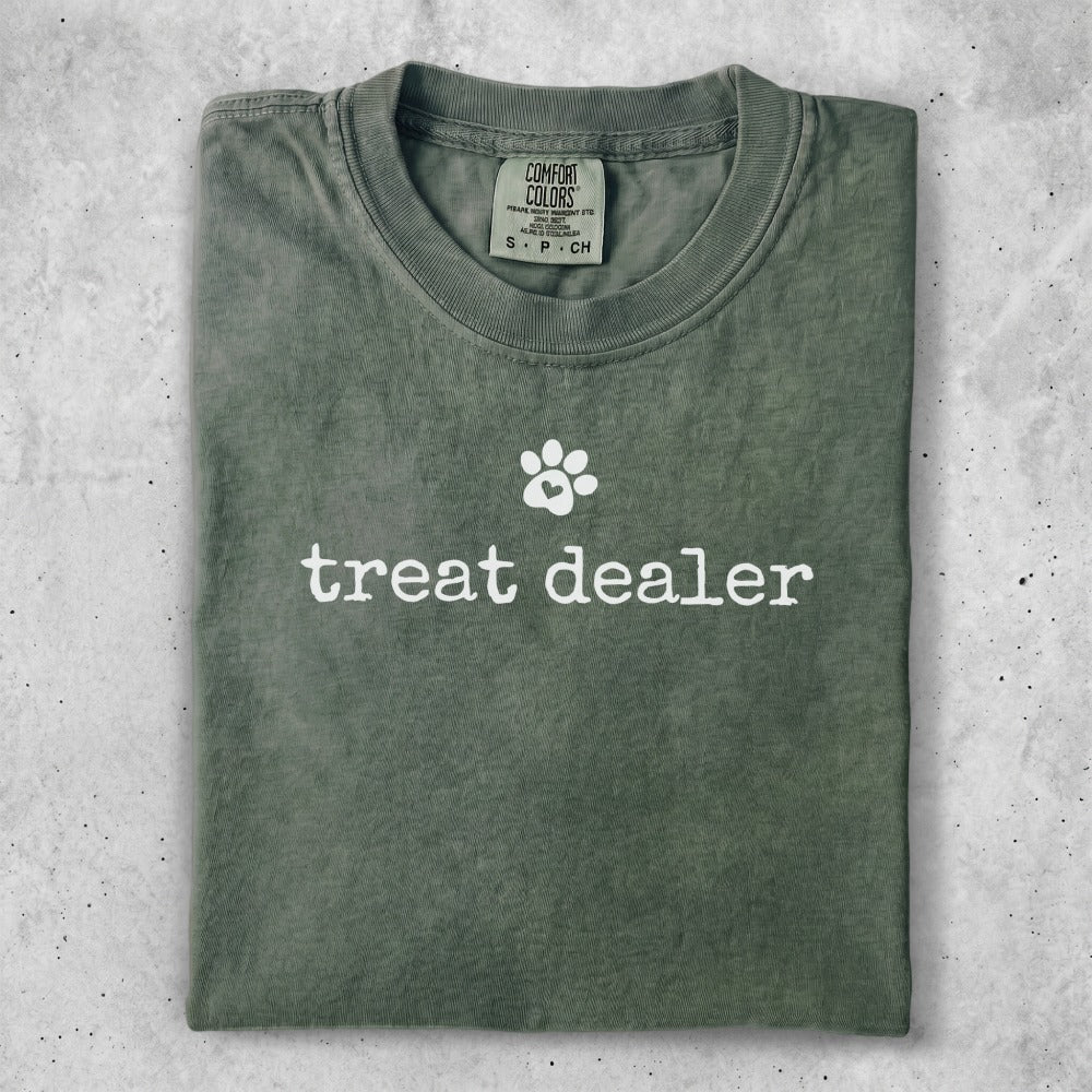 Green Comfort Colors t-shirt with "treat dealer" and a paw print.