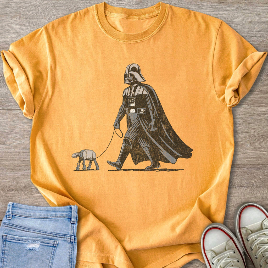Darth Vader walks an AT-ST walker on a leash on a yellow shirt.