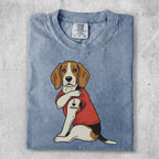 Beagle wearing a red shirt with "I LOVE MOM" tattoo on arm.