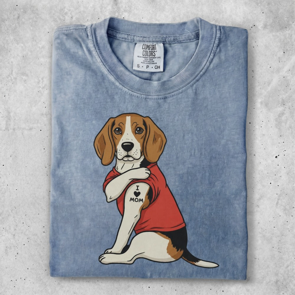 Beagle wearing a red shirt with "I LOVE MOM" tattoo on arm.