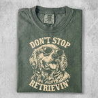 Green t-shirt with dog wearing sunglasses and text "Don't Stop Retrieving".