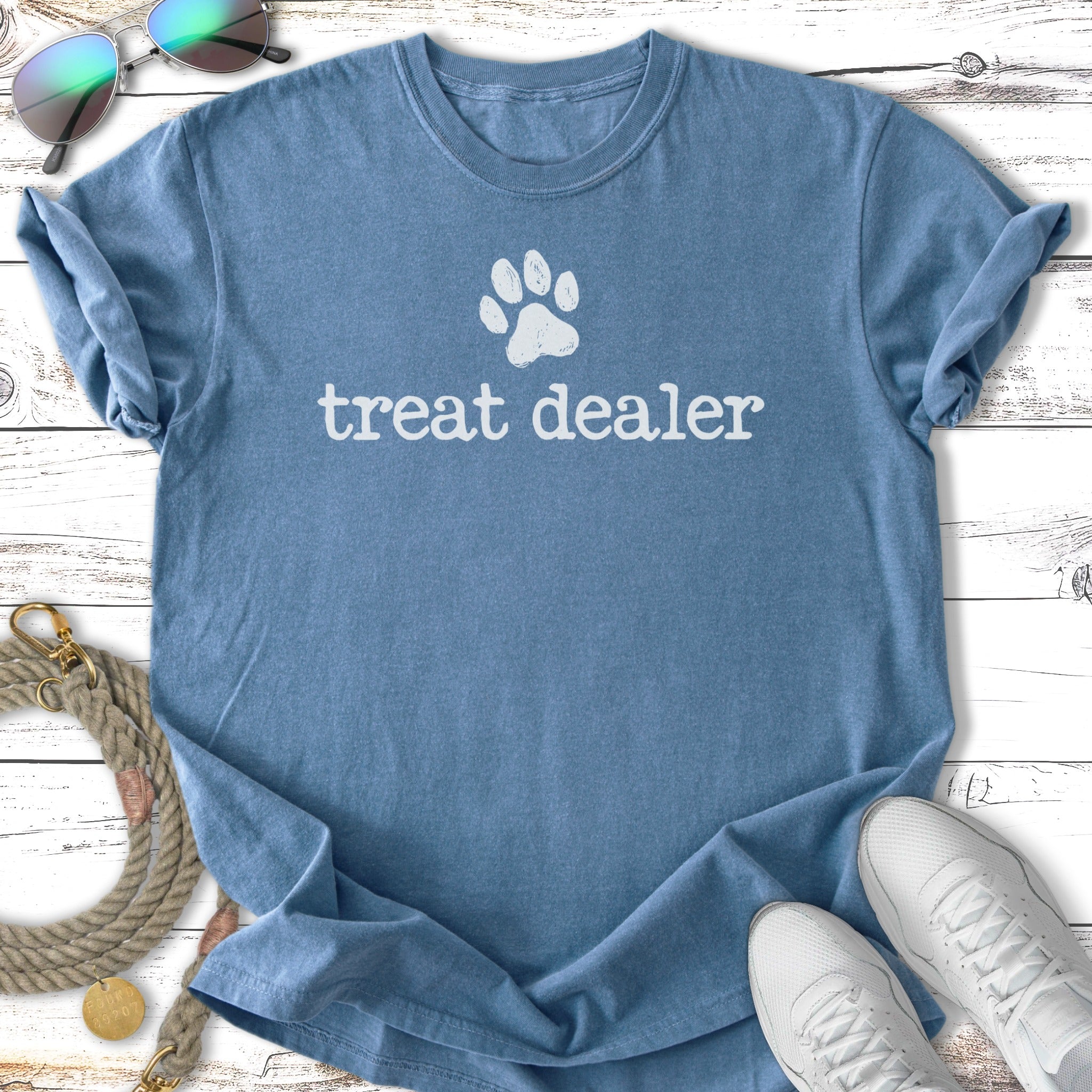 Blue t-shirt with white "treat dealer" paw print graphic.