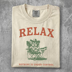 Cream t-shirt with "RELAX" above a dog in a cowboy hat drinking from a straw.