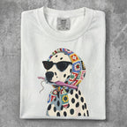 Dalmatian wearing sunglasses and a colorful scarf, holding a crochet hook.