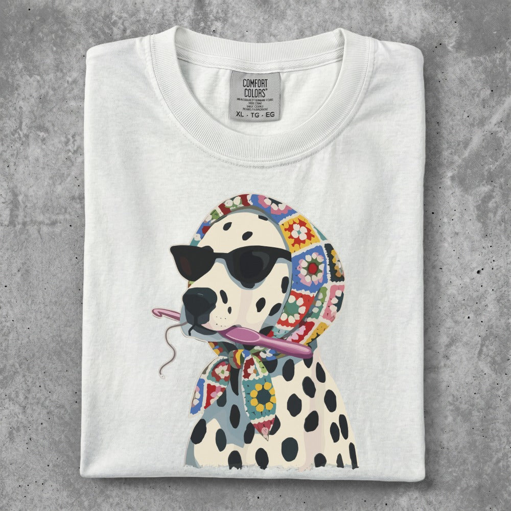 Dalmatian wearing sunglasses and a colorful scarf, holding a crochet hook.