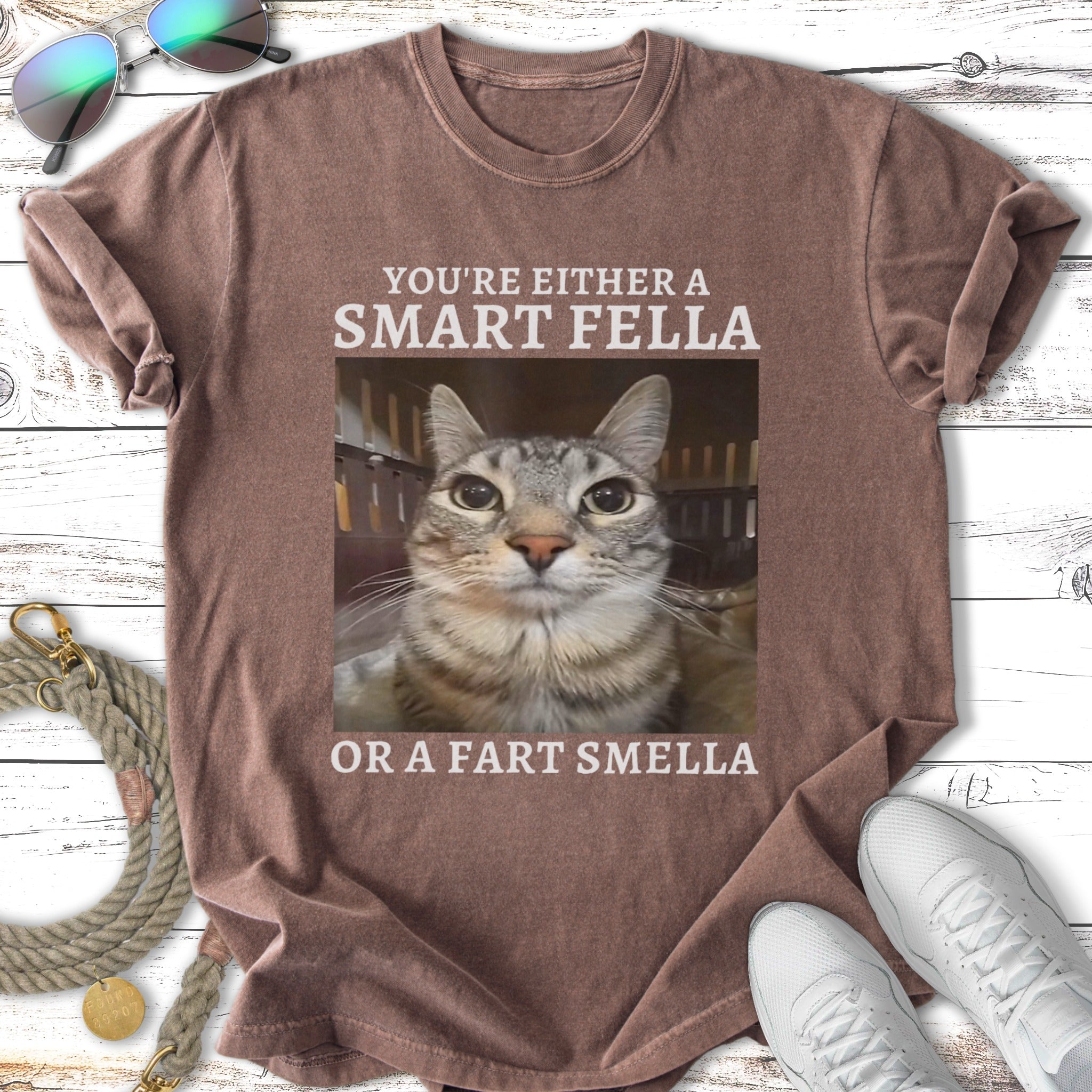 T-shirt with text "YOU'RE EITHER A SMART FELLA OR A FART SMELLA" and a cat's face.