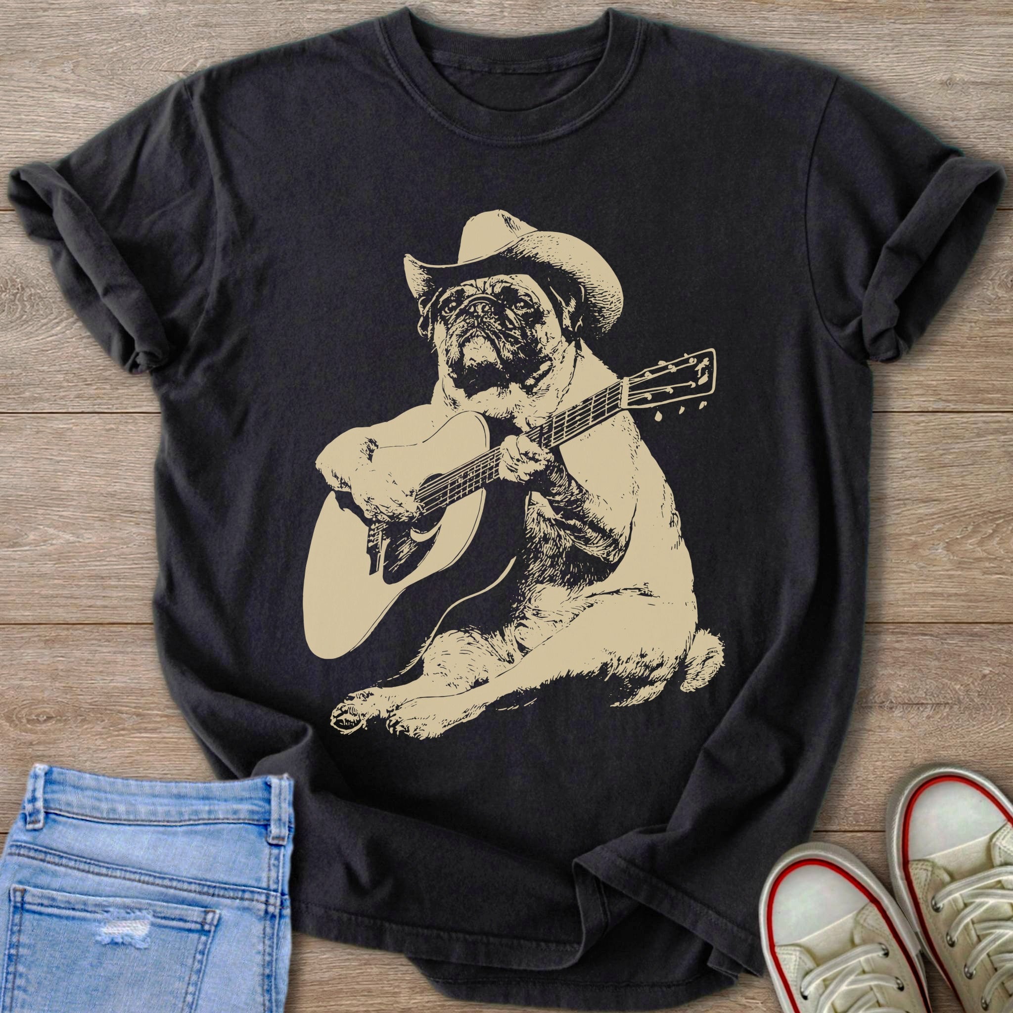Black t-shirt with a tan graphic of a pug wearing a cowboy hat playing a guitar.