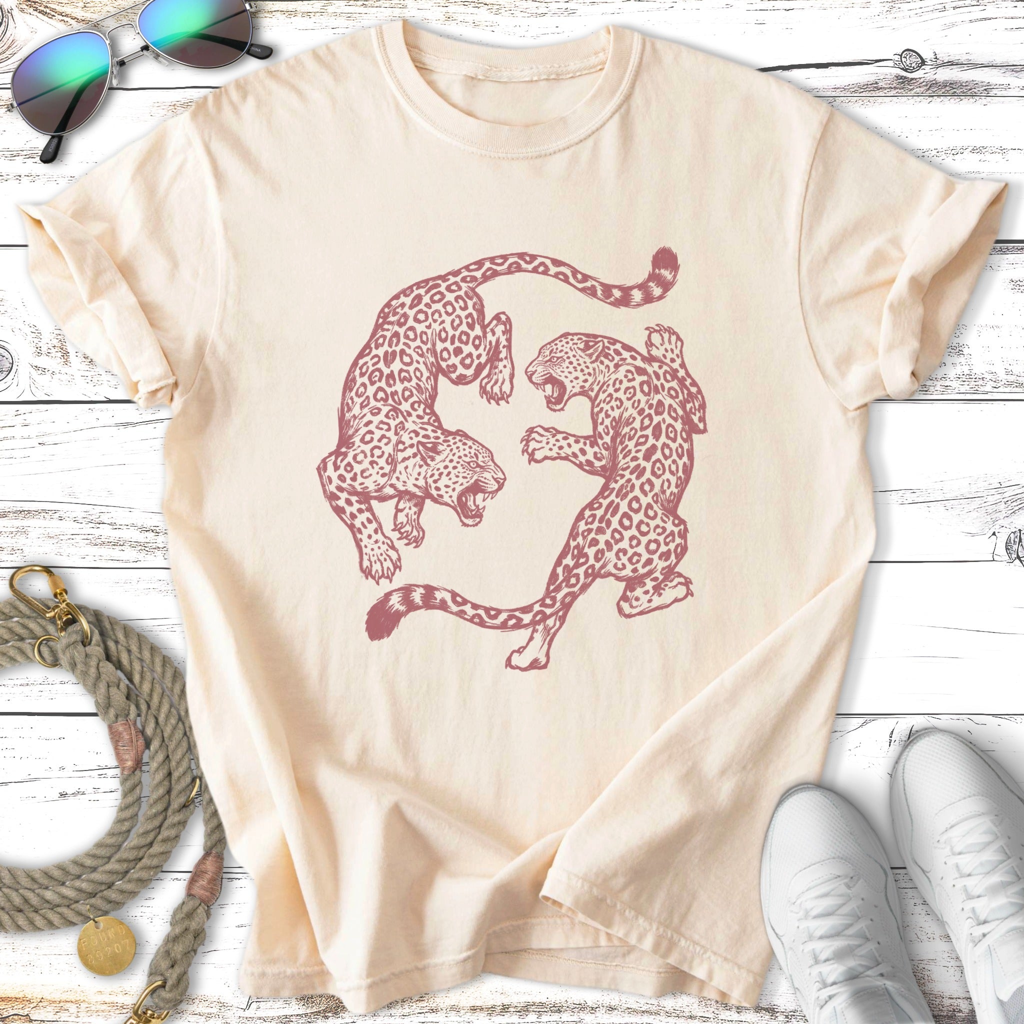 Cream t-shirt with two stylized leopards in a circular dance.