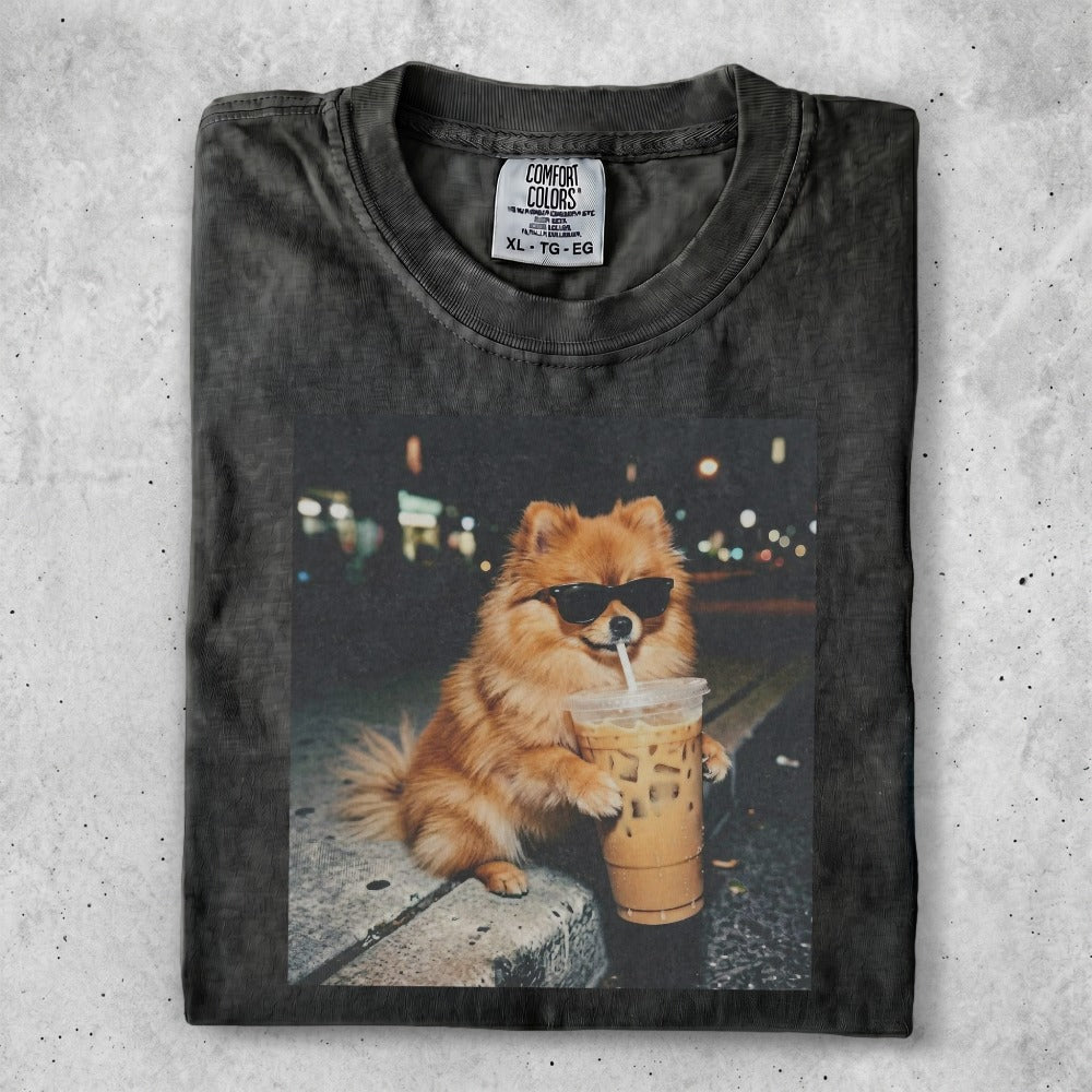 Fluffy Pomeranian dog wearing sunglasses holds a coffee cup.