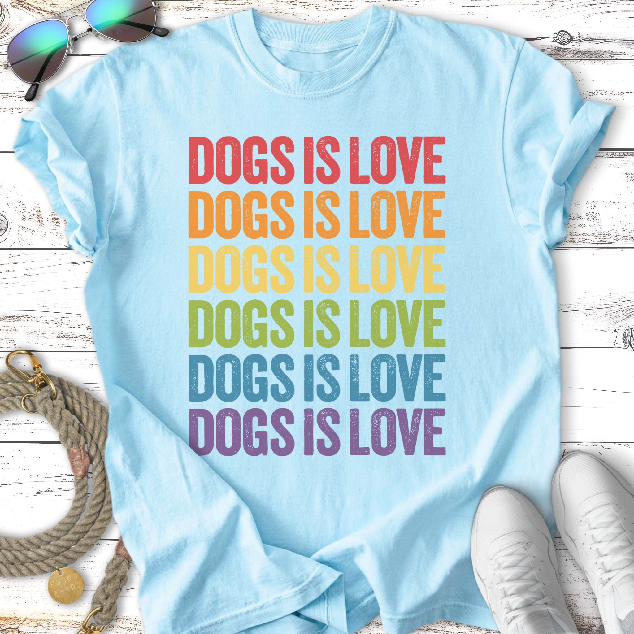 Light blue t-shirt with "DOGS IS LOVE" in rainbow gradient text.