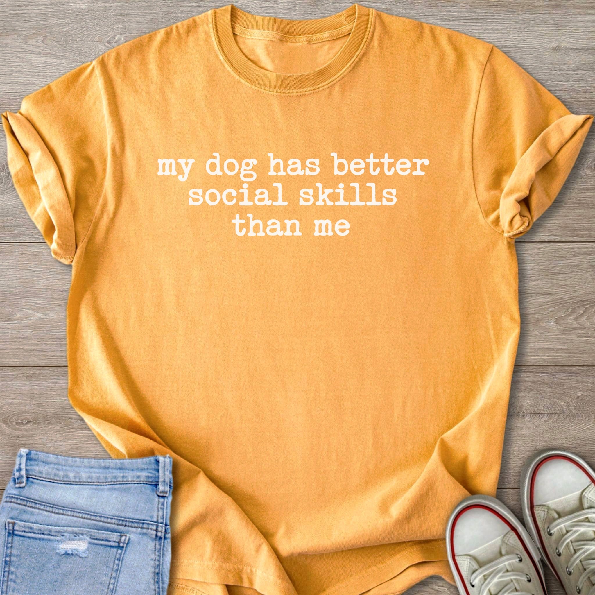 Orange t-shirt with white text "my dog has better social skills than me."