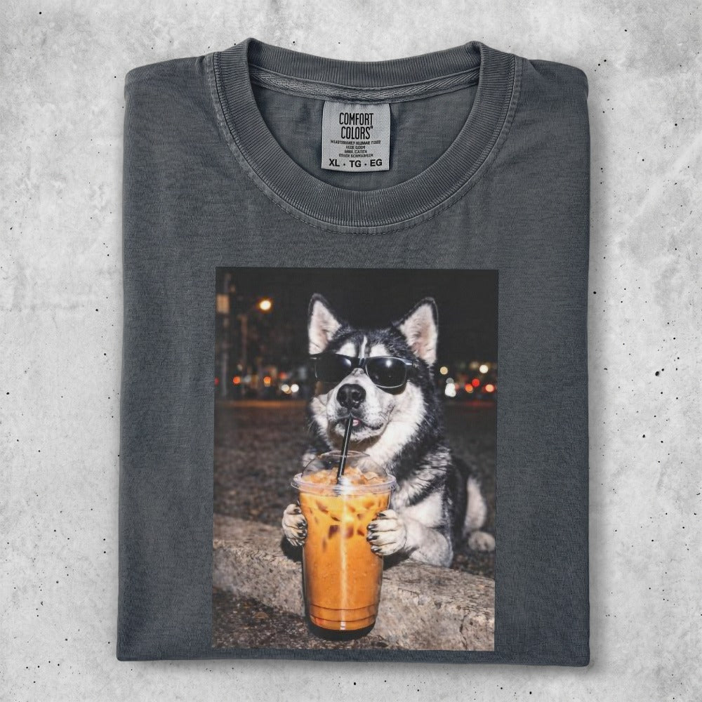 Husky wearing sunglasses holds a coffee drink with a straw.