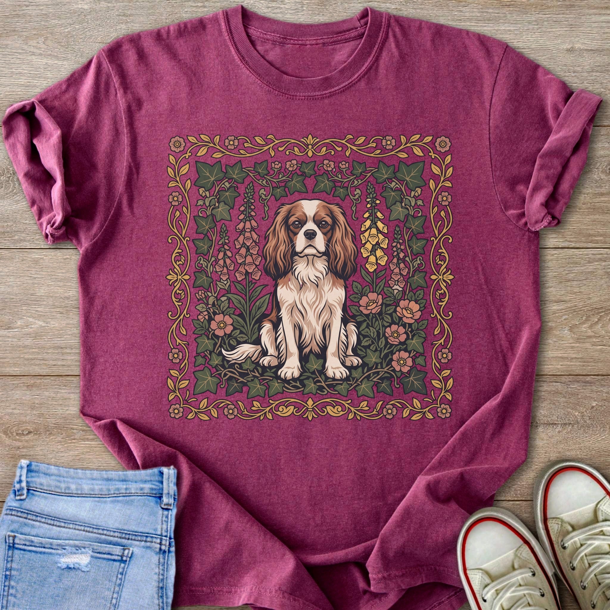 Burgundy t-shirt with Cavalier King Charles Spaniel in floral frame on wood background