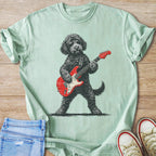 Black dog wearing sunglasses plays a red electric guitar on a light green shirt.