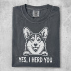 Dark gray t-shirt with a smiling corgi illustration and the text "YES, I HERD YOU."