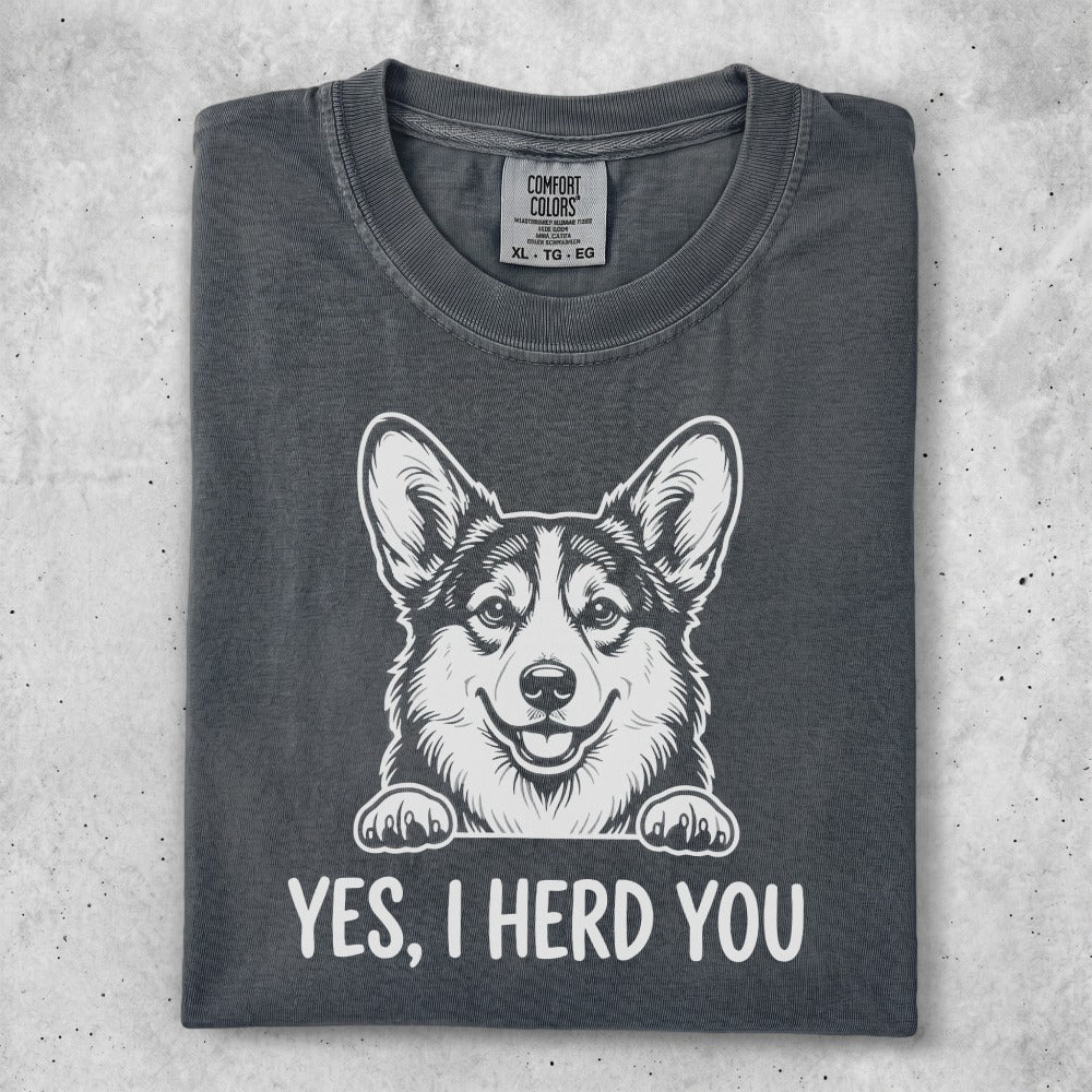 Dark gray t-shirt with a smiling corgi illustration and the text "YES, I HERD YOU."