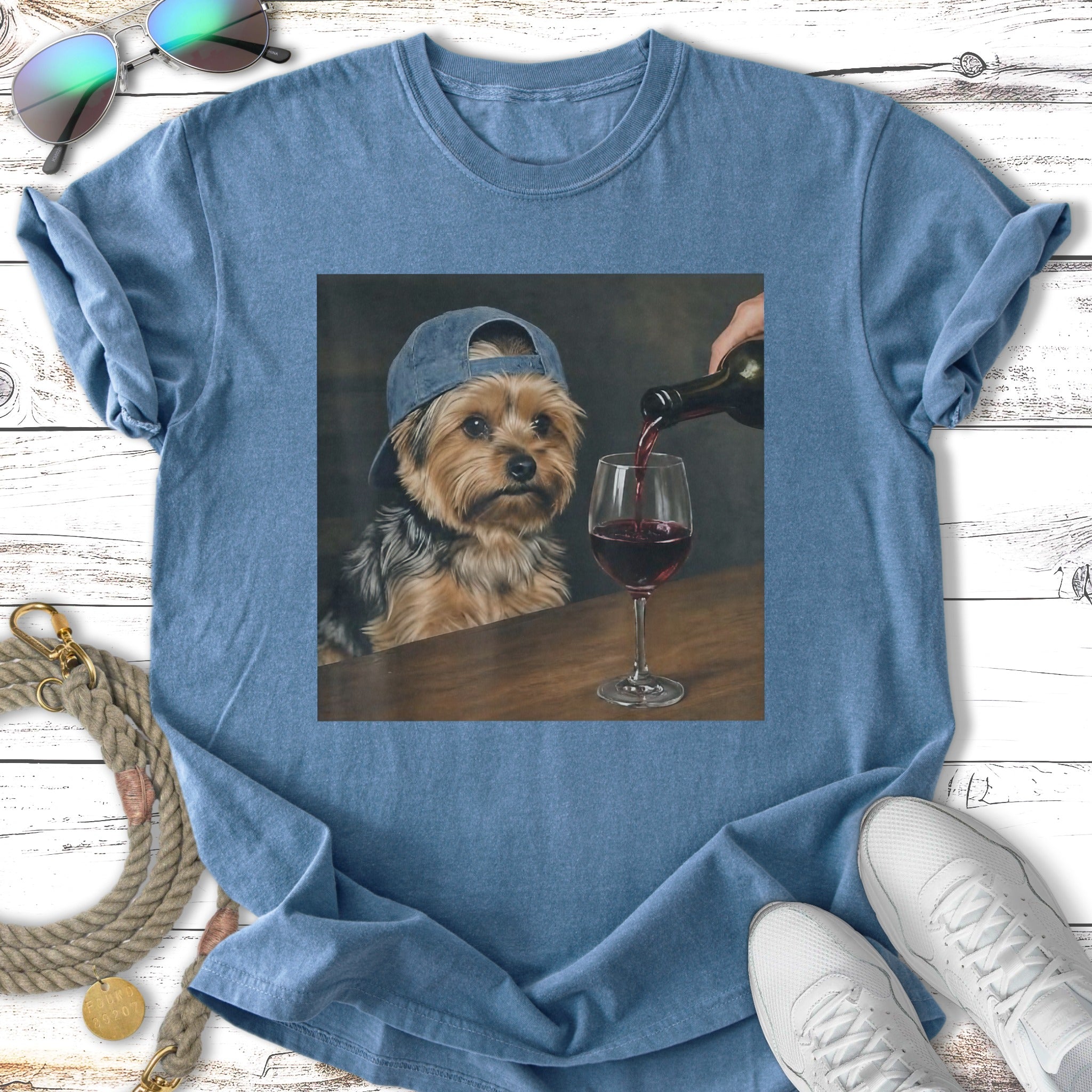 Yorkshire terrier wearing a baseball cap pours red wine into a glass.