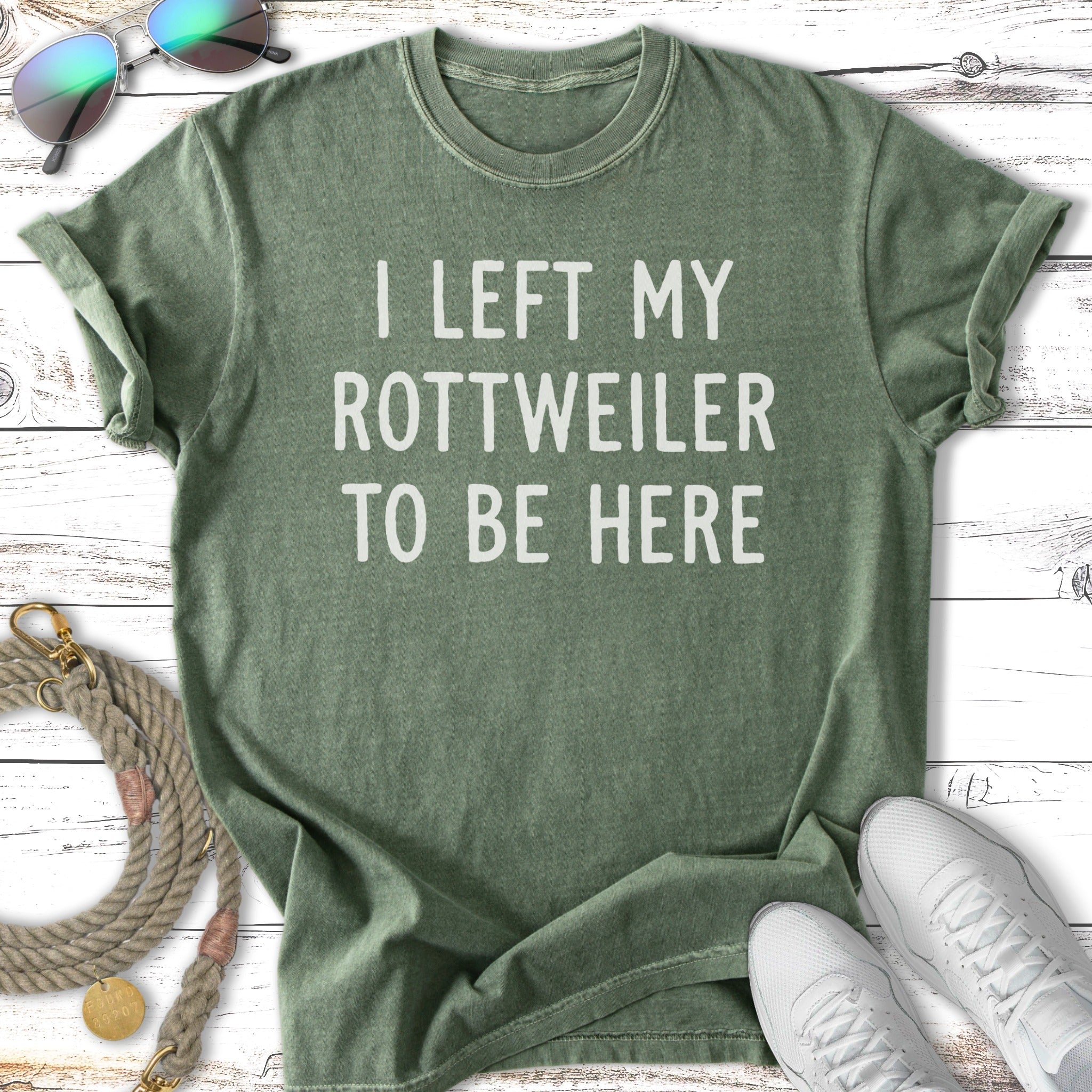 Green t-shirt with white text "I LEFT MY ROTTWEILER TO BE HERE".