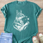 Teal t-shirt with a white line drawing of a German Shepherd holding a dandelion.