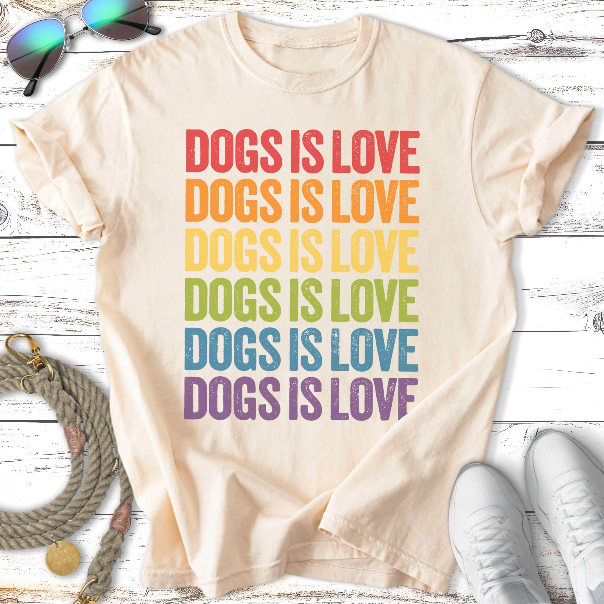 Cream t-shirt with rainbow text "DOGS IS LOVE" repeated.
