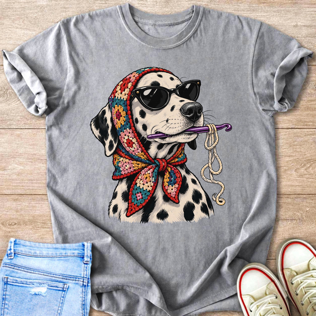 Dalmatian wearing sunglasses and a crocheted scarf holds a crochet hook and yarn.