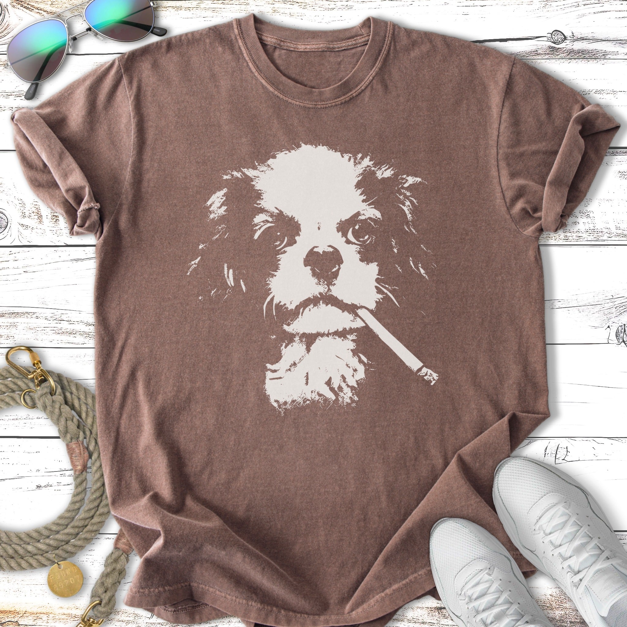 T-shirt with a white graphic of a Cavalier King Charles Spaniel wearing sunglasses and smoking.