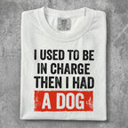 White t-shirt with "I USED TO BE IN CHARGE THEN I HAD A DOG" text.