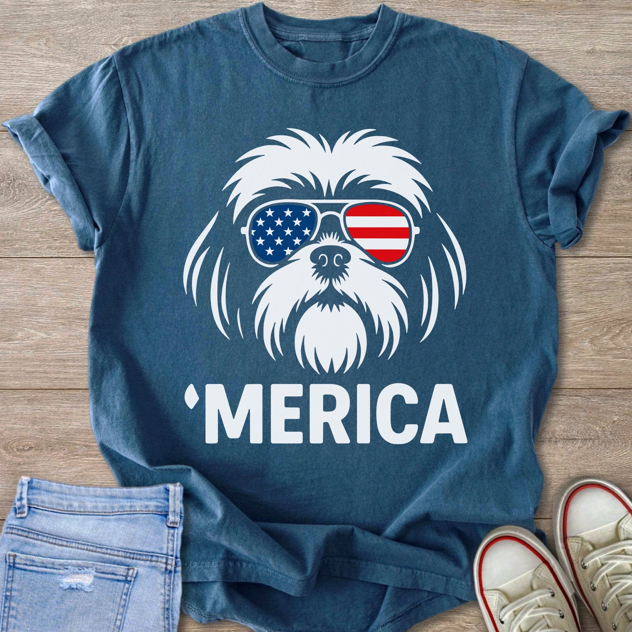 White dog wearing American flag sunglasses and "Merica" text on blue t-shirt