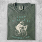 Green t-shirt with pug riding bicycle and text "Born to dilly dally".