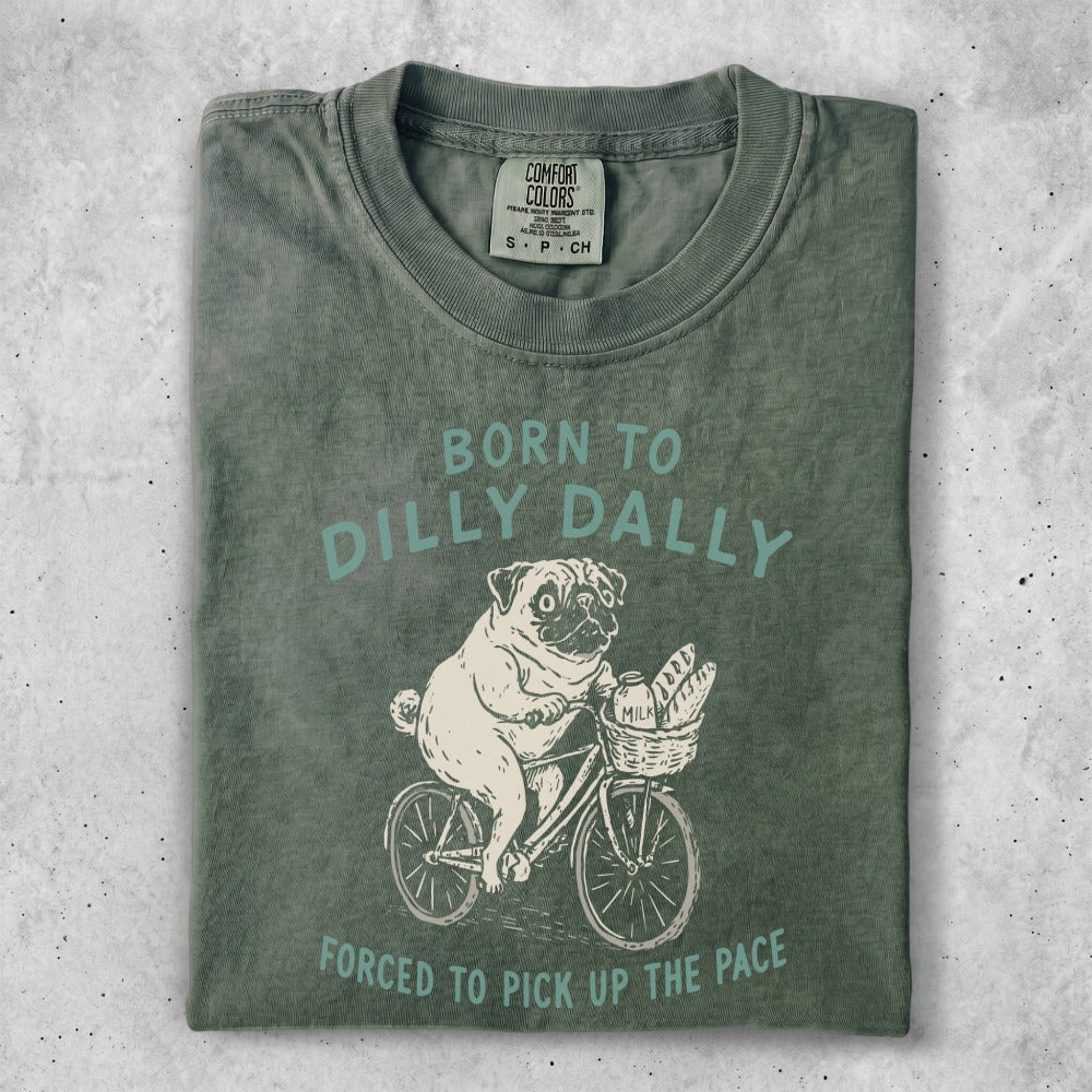 Green t-shirt with pug riding bicycle and text "Born to dilly dally".