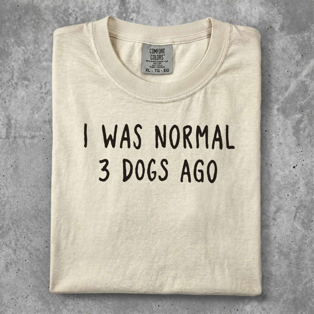 Cream t-shirt with "I WAS NORMAL 3 DOGS AGO" text in black.