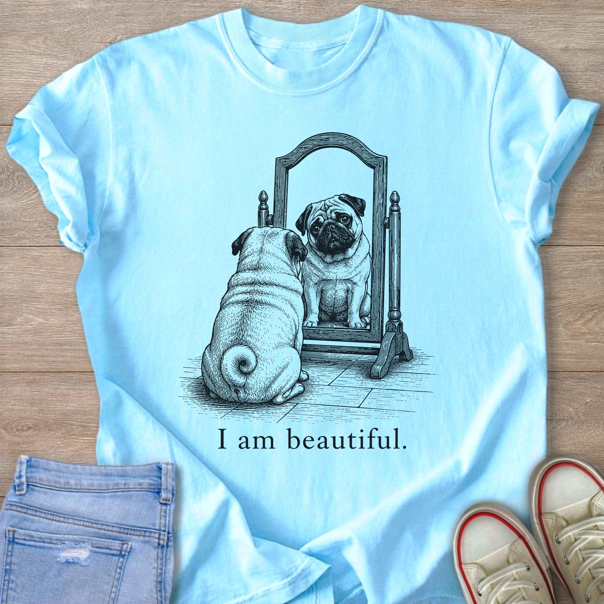 Light blue t-shirt with pug looking in mirror and "I am beautiful." text.