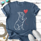 French bulldog holding a red heart balloon on a blue t-shirt.