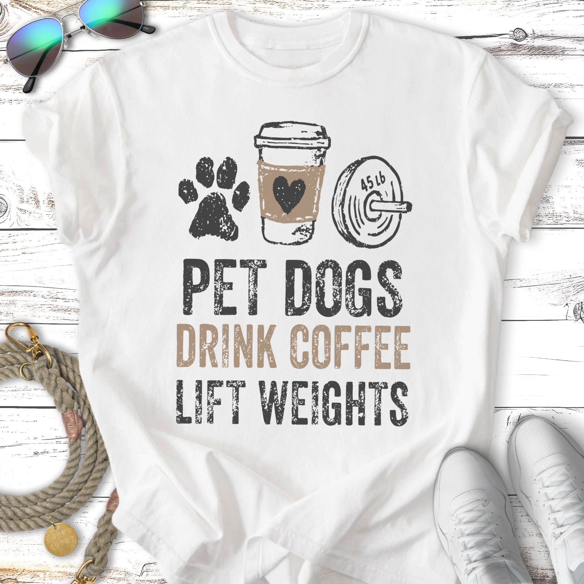 White t-shirt with "Pet dogs drink coffee lift weights" text and graphics.