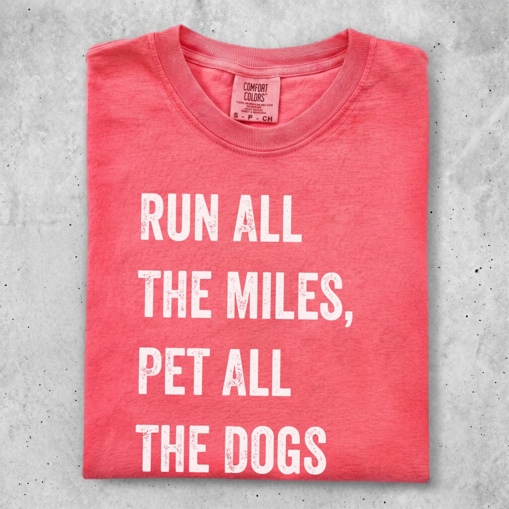 Coral t-shirt with white text reading "RUN ALL THE MILES, PET ALL THE DOGS".