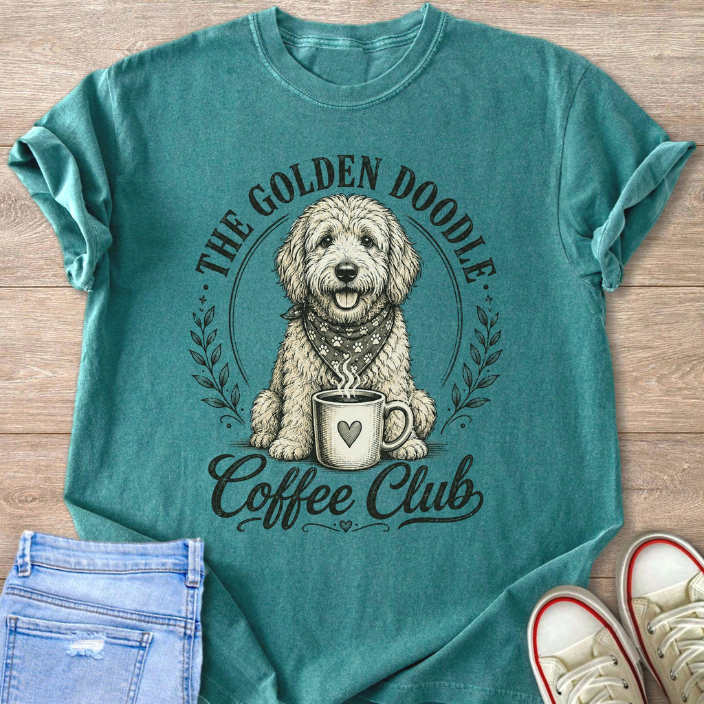 Teal t-shirt features cartoon doodle with coffee cup, text "The Golden Doodle Coffee Club".