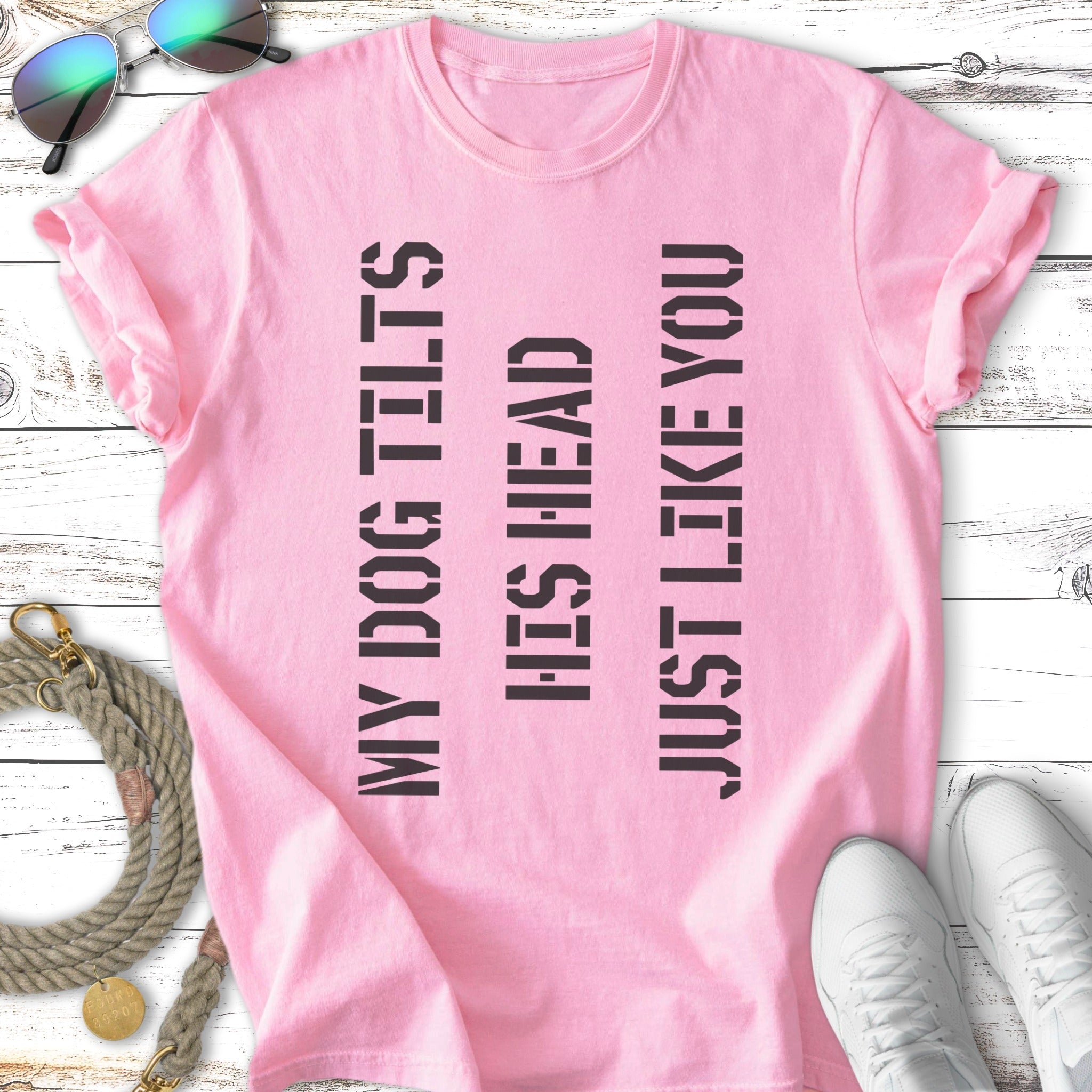 Pink t-shirt with black text: "MY DOG TILTS HIS HEAD JUST LIKE YOU".