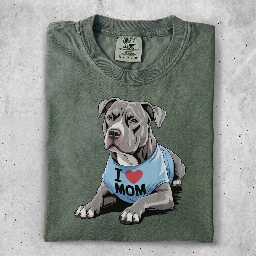 Pitbull wearing a blue "I Love Mom" shirt, lying down.