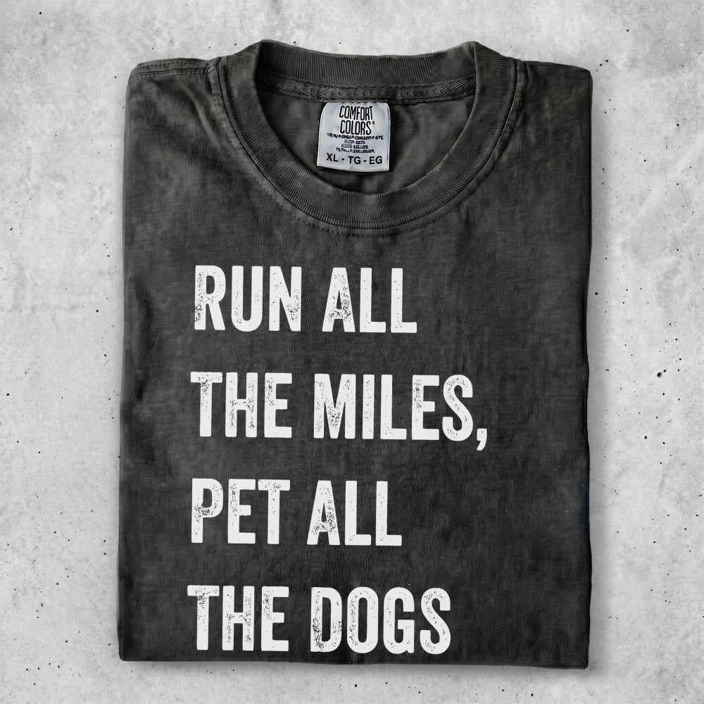 Dark t-shirt with white text "Run all the miles, pet all the dogs."