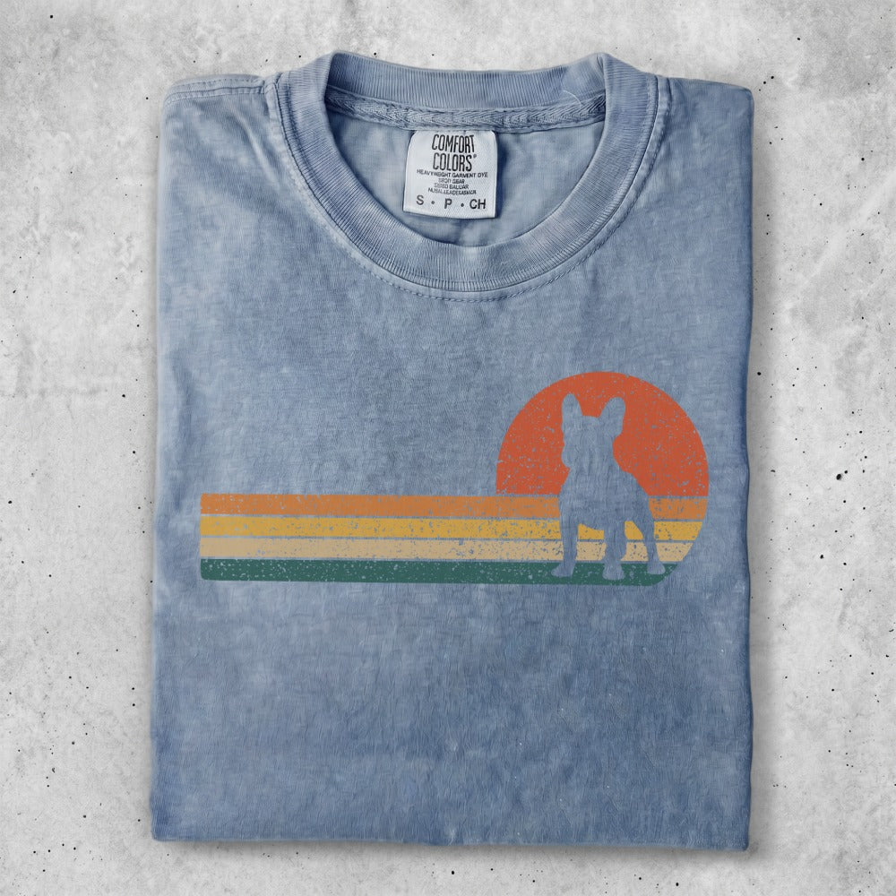 Blue t-shirt with a French bulldog silhouette against a retro sunset graphic.