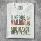 White t-shirt with "I like dogs, mahjong and maybe three people" text and paw print graphic.