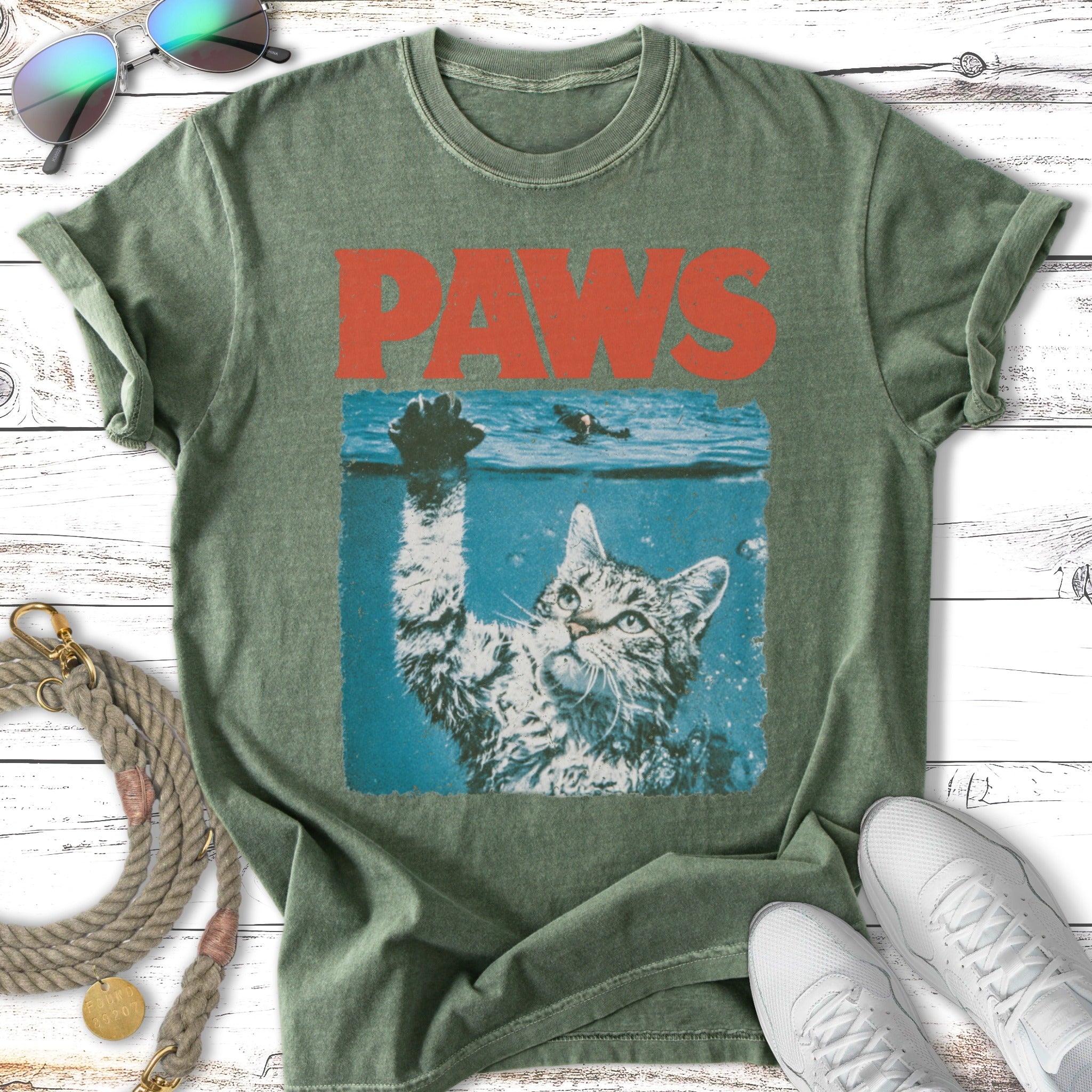 Cat reaching up from underwater, "PAWS" graphic above.