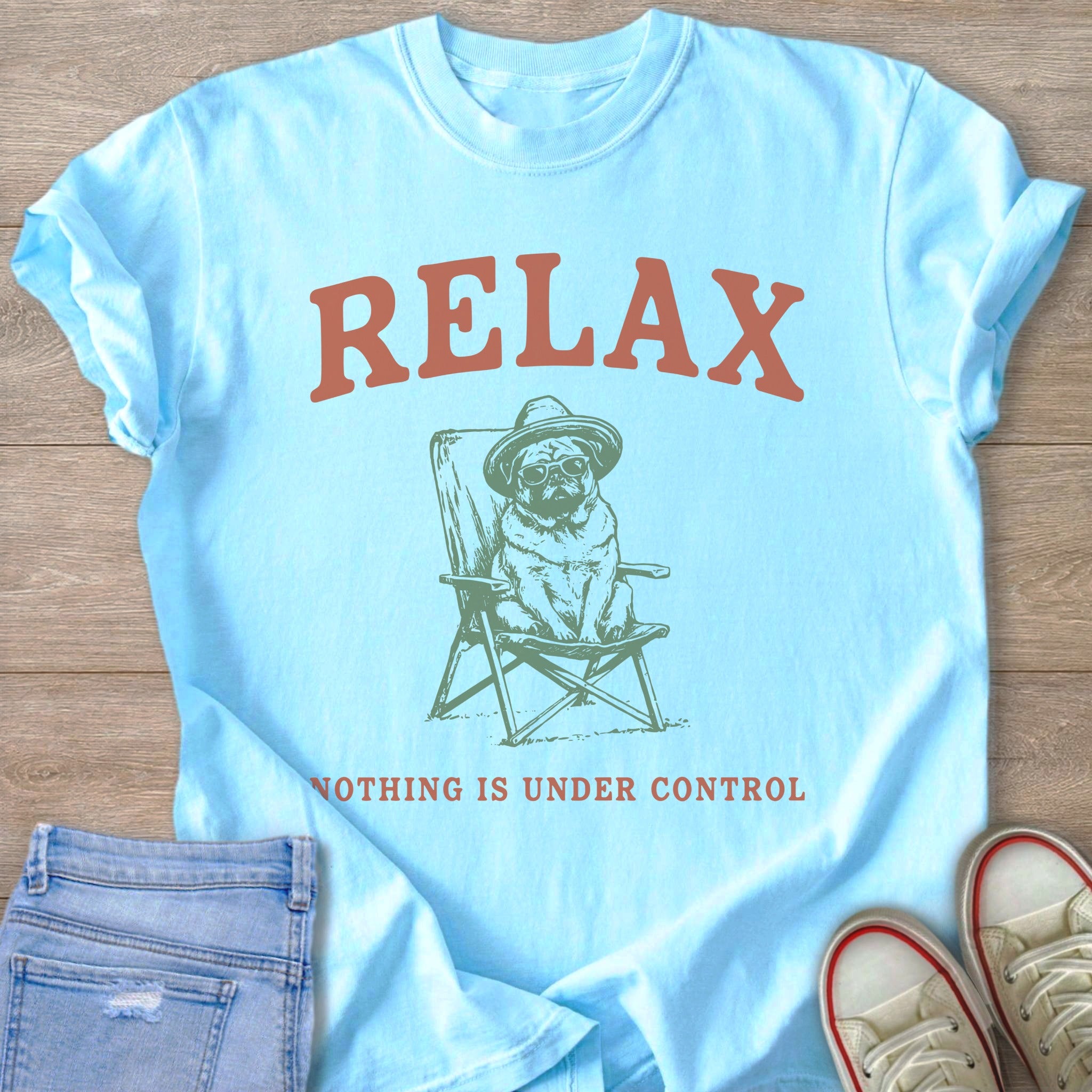 Light blue t-shirt with "RELAX" and dog sitting in a chair.
